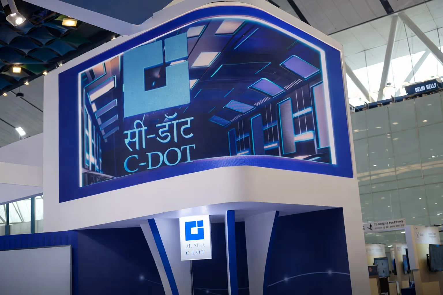 Exhibition booth with C-DOT logo and text in Hindi and English at a convention center.
