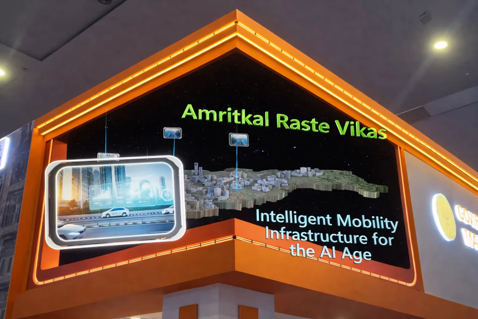 Exhibition display with text 'Amritkal Raste Vikas' and 'Intelligent Mobility Infrastructure for the AI Age' accompanied by a 3D city model