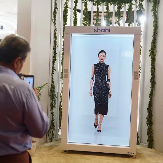 A visitor photographs a model walking on the Shahi Exports HoloBox at Bharat Tex 2026