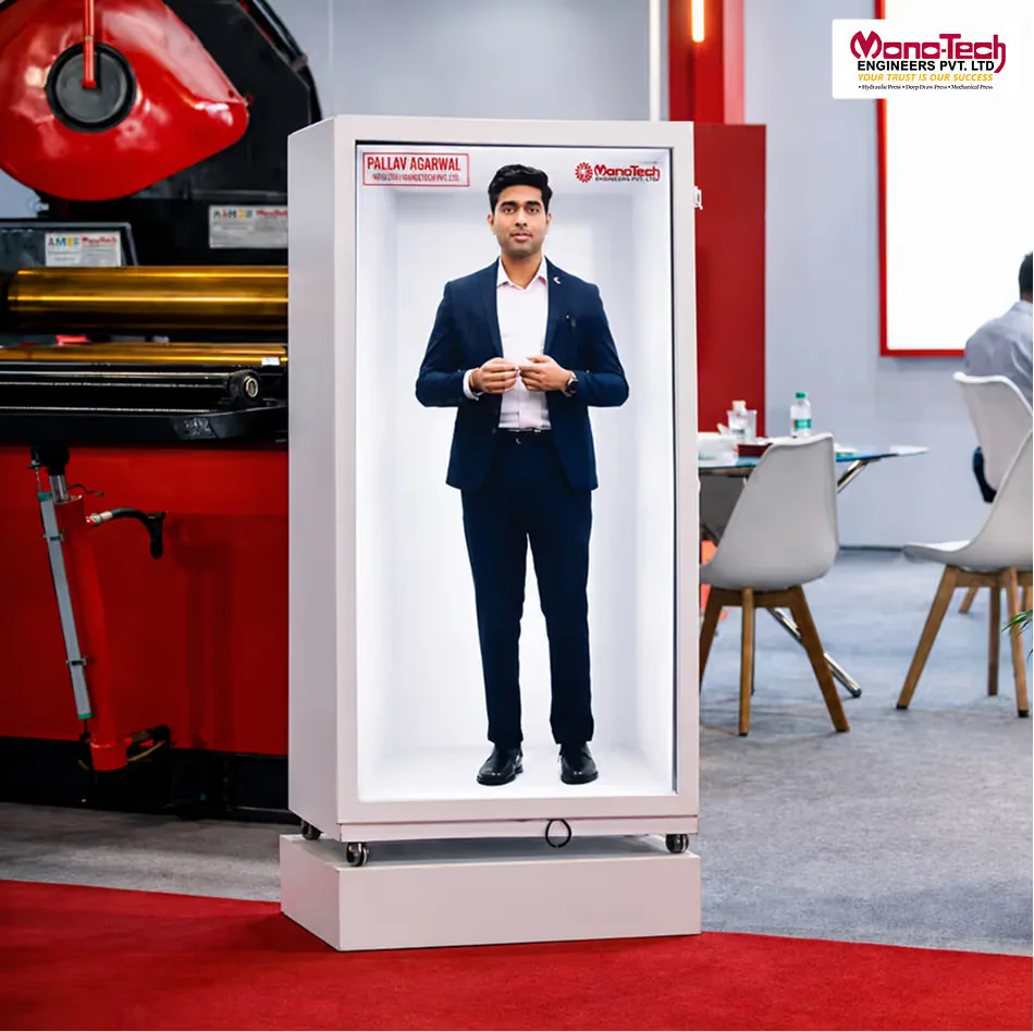The Monotech Engineers stand at IMTOS 2025: a HoloBox911 holographic display on a white plinth showing a life-size recorded welcome, with