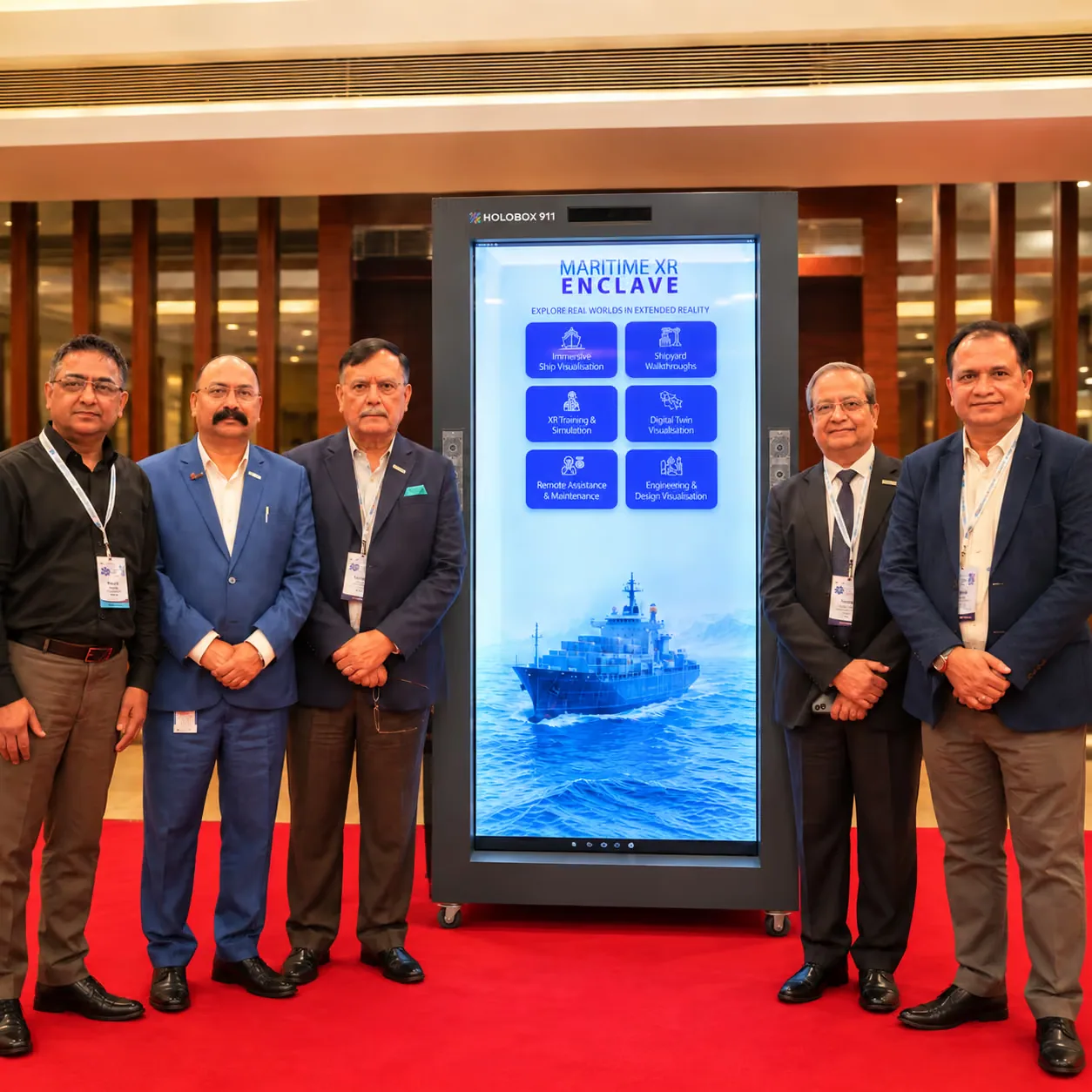 Delegates beside a HoloBox911 display showing maritime extended reality capabilities at the Maritime XR Conclave 2026, Indian Register of