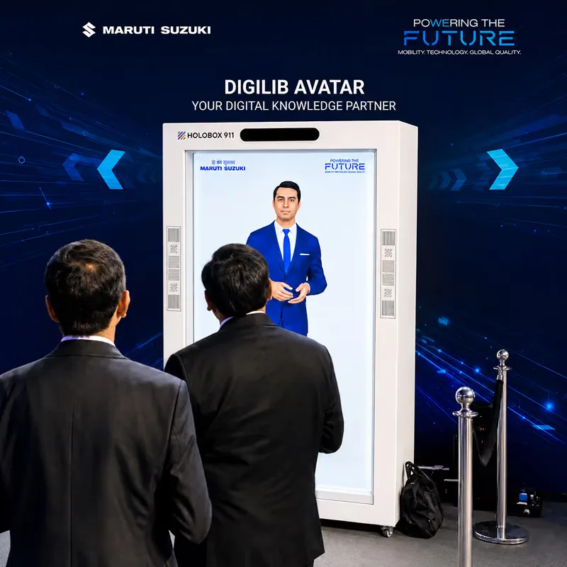 Two delegates standing at the HoloBox911 unit at the Maruti Suzuki Vendor Conference, the enclosure carrying the HoloBox 911 name and the